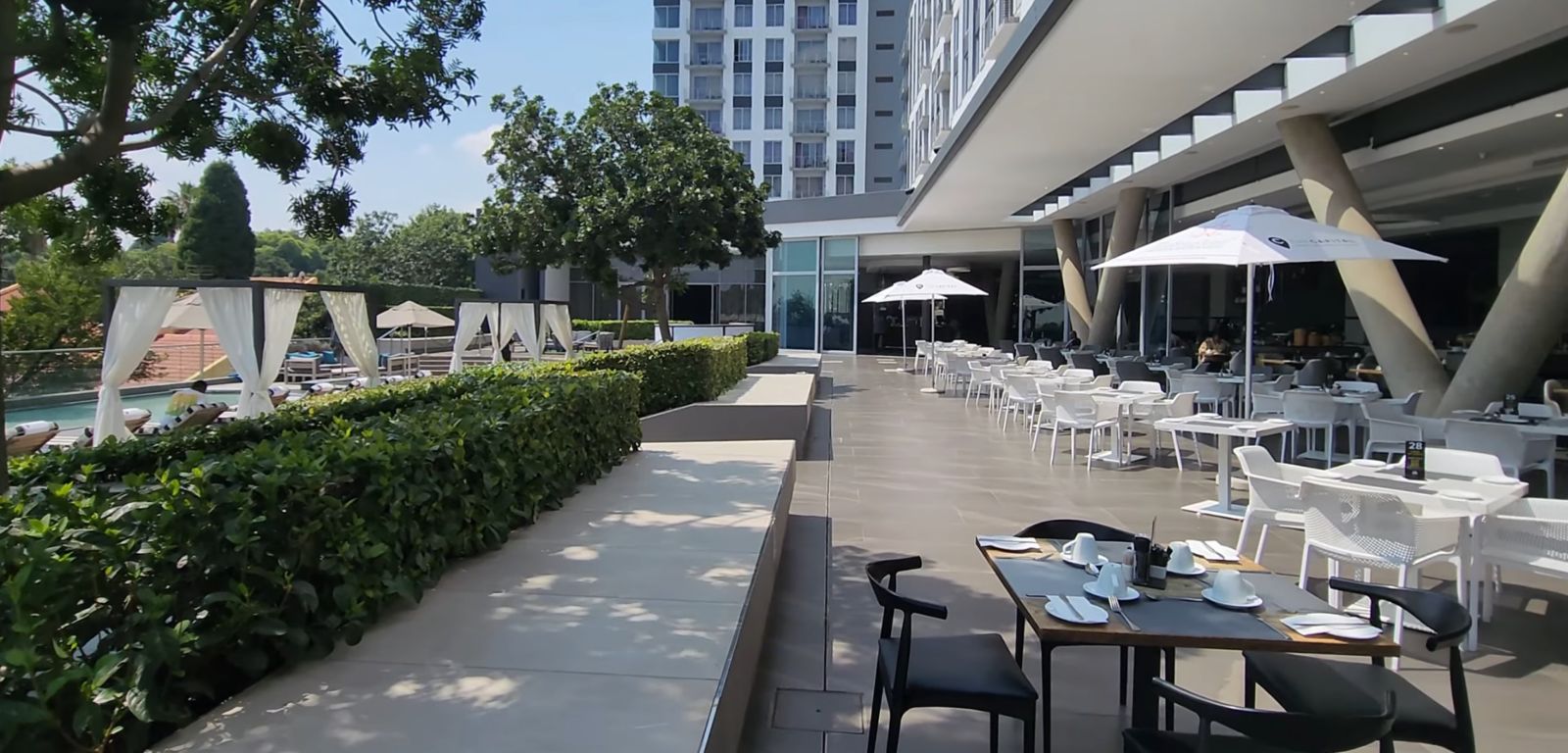 Outdoor terrace restaurant with pool views and dining tables